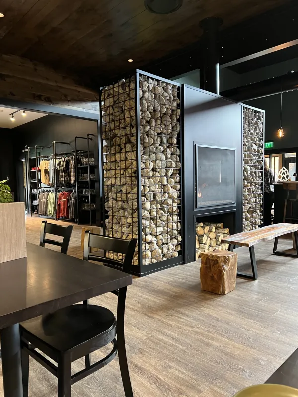 Double sided fireplace surrounded with industrial columns filled with stones.