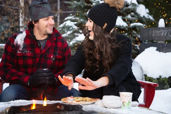 A couple warms by the fire pit