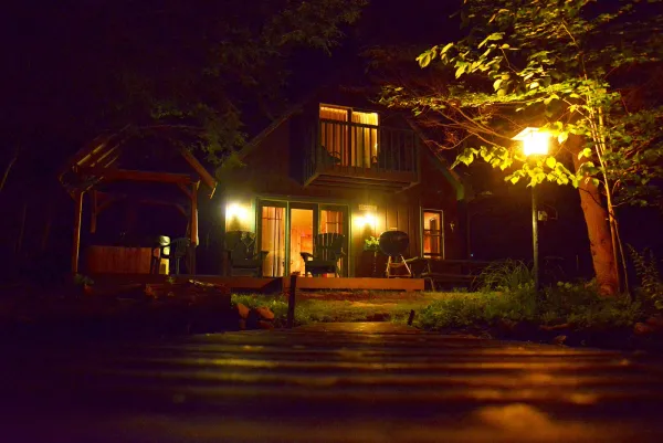 The exterior of the house at night, glowing from within.