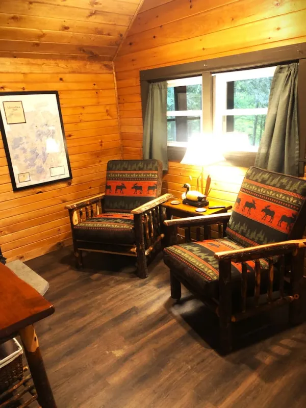 The living space with two rustic armchairs at Rockledge Cabins & Retreats 