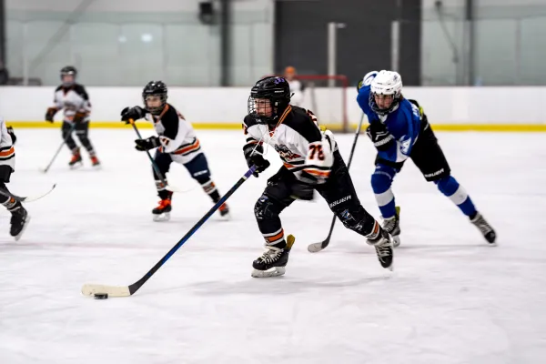 Youth hockey players in action on the ice, showcasing teamwork and skill.