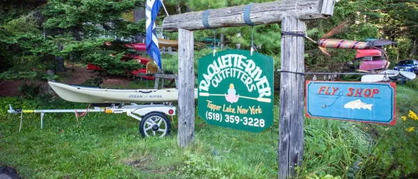The green sign for Raquette River Outfitters