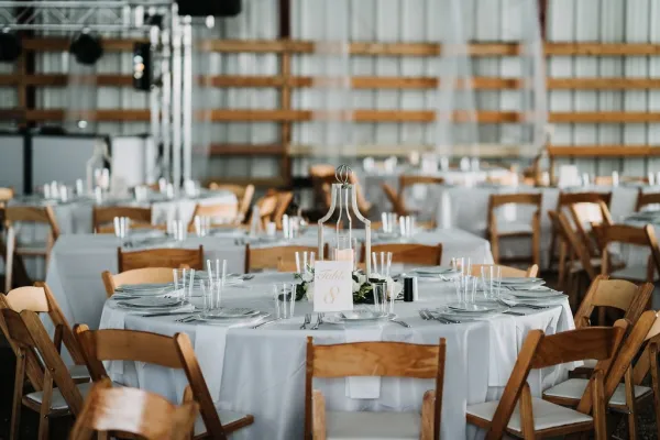 tables set for an event in a barn