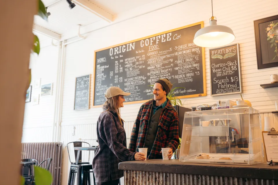 A man and woman share coffee at a coffee shop. 