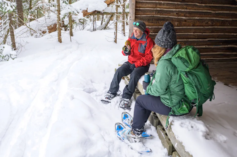 Two snowshoers at a lean-to.
