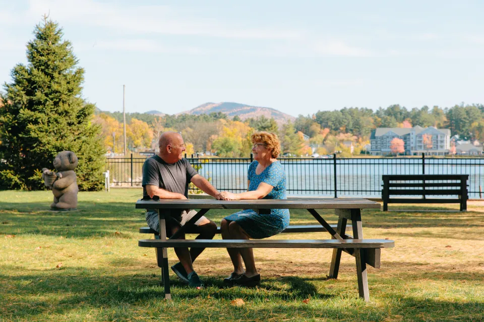 A couple sitting at a park in the fall.