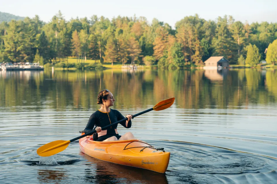 A woman paddling a kayak in Saranac Lake.