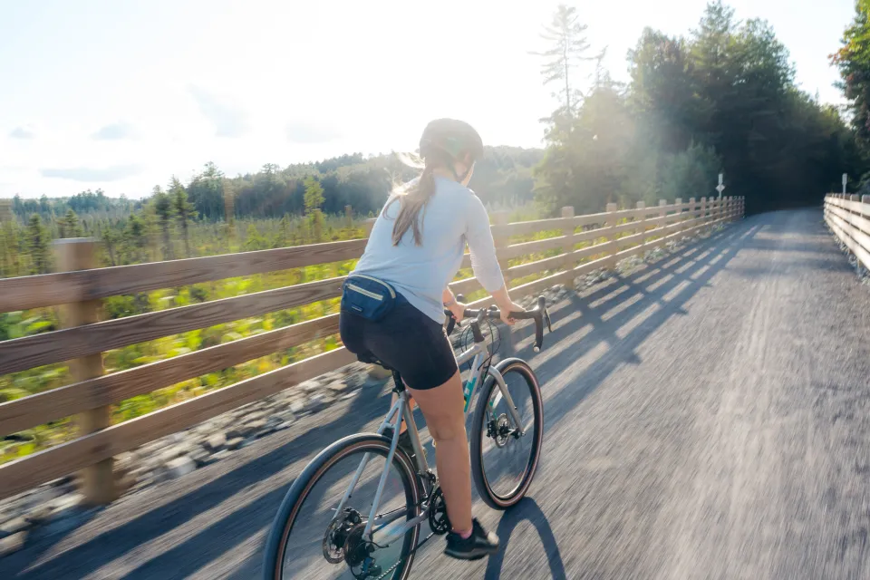 A woman riding her bike on the Adirondack Rail Trail.